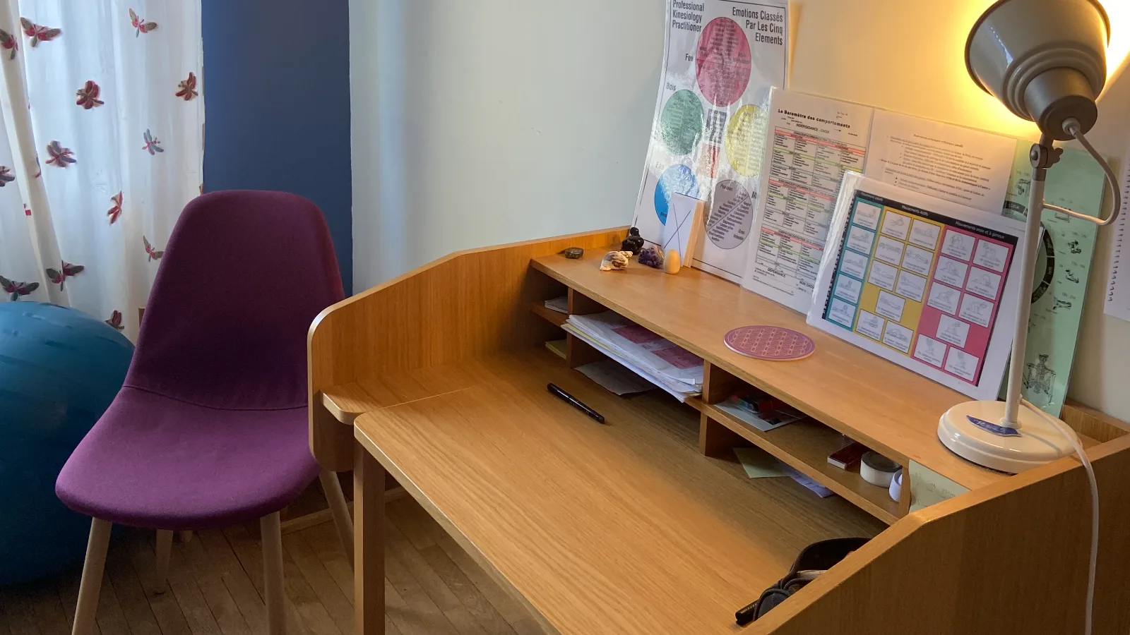 Bureau en bois avec des documents de kinésiologie posés dessus