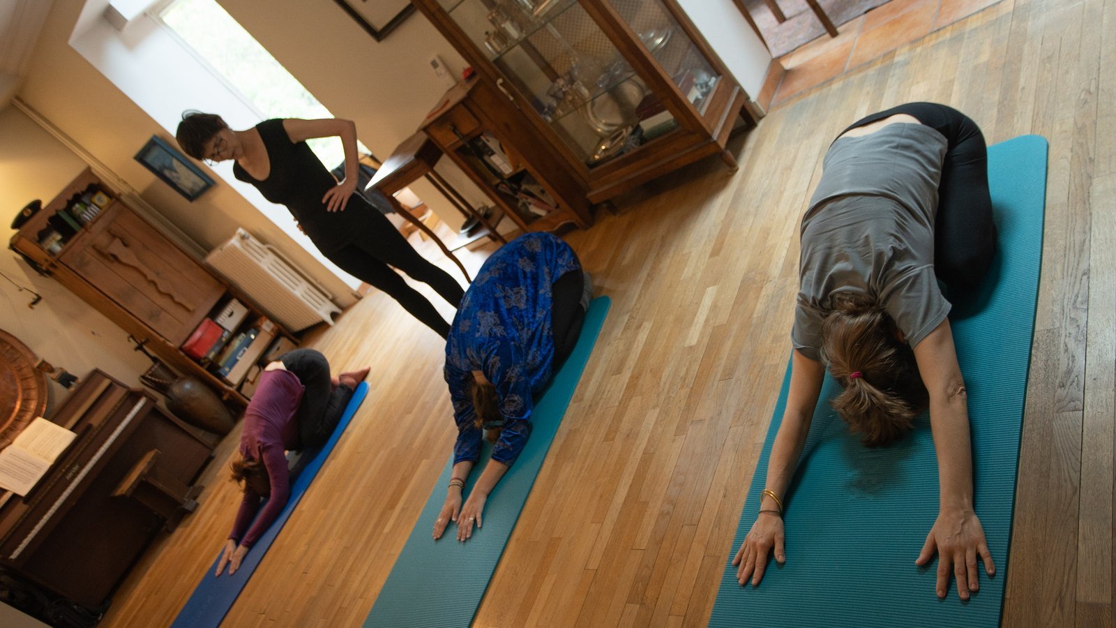 Le cours en petit groupe dans la salle, parquet, piano et vitrine en fond.